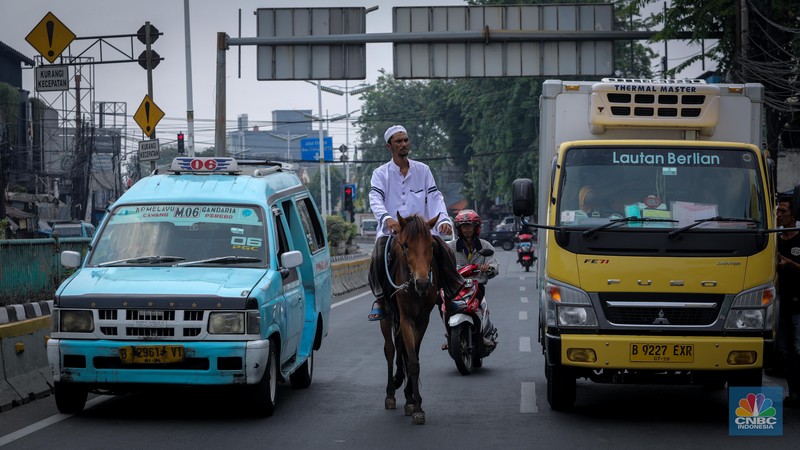 Seorang pria bernama Abdullah nampak menunggangi kuda saat melintas di Jalan Dewi Sartika, Jakarta Timur, Jumat (8/9/2023). (CNBC Indonesia/Faisal Rahman)