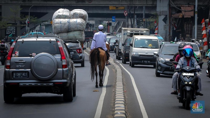 Seorang pria bernama Abdullah nampak menunggangi kuda saat melintas di Jalan Dewi Sartika, Jakarta Timur, Jumat (8/9/2023). (CNBC Indonesia/Faisal Rahman)