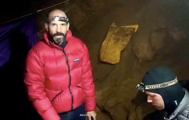 Tim penyelamat Turki dan Bulgaria berdiri di pintu masuk Gua Morca saat mereka mengambil bagian dalam operasi penyelamatan untuk mencapai penjelajah gua AS Mark Dickey yang jatuh sakit dan terjebak sekitar 1.000 meter (3.280 kaki) di bawah tanah, dekat Anamur di provinsi Mersin, Turki selatan 8 September , 2023. (REUTERS/Umit Bektas)