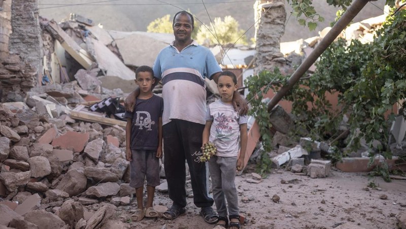 Mohammed Elhmatif and his sons, Rayan, right, and Ali, stand amidst the rubble of their home which was damaged by the earthquake, in Ijjoukak village, near Marrakech, Morocco, Saturday, Sept. 9, 2023. A rare, powerful earthquake struck Morocco, sending people racing from their beds into the streets and toppling buildings in mountainous villages and ancient cities not built to withstand such force. (AP Photo/Mosa'ab Elshamy)