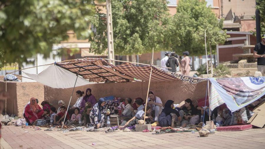 Orang-orang berlindung di tenda-tenda setelah rumah mereka rusak akibat gempa bumi, di kota Amizmiz, dekat Marrakesh, Maroko, Minggu, 10 September 2023. Kota-kota dan desa-desa di seluruh Pegunungan Atlas Maroko berduka atas kematian dan mencari bantuan setelah rekor gempa bumi mendatangkan kehancuran di seluruh wilayah minggu lalu. (AP Photo/Mosa'ab Elshamy)