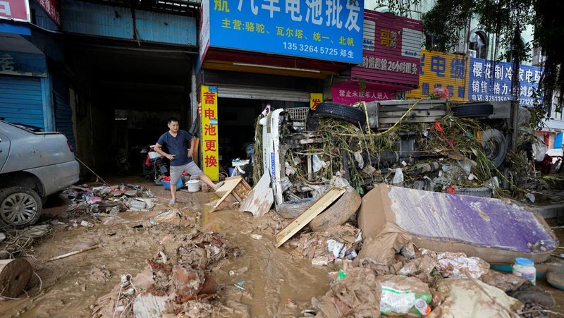 Seorang pria membersihkan rumah setelah hujan deras membanjiri kota Tangxia di Dongguan, provinsi Guangdong, Cina 9 September 2023. (REUTERS/Aly Song)