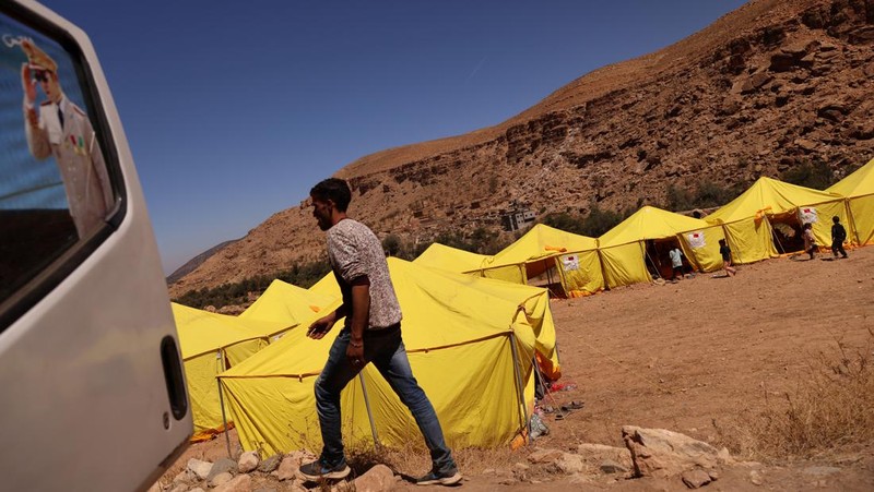 Orang-orang berlindung di tenda-tenda setelah rumah mereka rusak akibat gempa bumi, di kota Amizmiz, dekat Marrakesh, Maroko, Minggu, 10 September 2023. Kota-kota dan desa-desa di seluruh Pegunungan Atlas Maroko berduka atas kematian dan mencari bantuan setelah rekor gempa bumi mendatangkan kehancuran di seluruh wilayah minggu lalu. (AP Photo/Mosa'ab Elshamy)