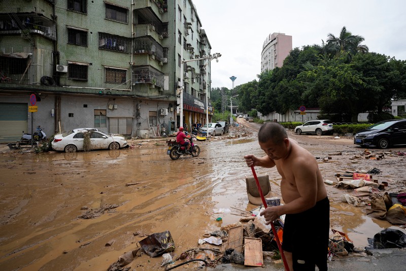 Seorang pria membersihkan rumah setelah hujan deras membanjiri kota Tangxia di Dongguan, provinsi Guangdong, Cina 9 September 2023. Seorang pria membersihkan rumah setelah hujan deras membanjiri kota Tangxia di Dongguan, provinsi Guangdong, Cina 9 September 2023. (REUTERS/Aly Song)
