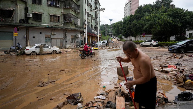 Seorang pria membersihkan rumah setelah hujan deras membanjiri kota Tangxia di Dongguan, provinsi Guangdong, Cina 9 September 2023. (REUTERS/Aly Song)