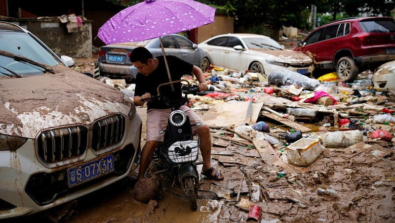 Seorang pria membersihkan rumah setelah hujan deras membanjiri kota Tangxia di Dongguan, provinsi Guangdong, Cina 9 September 2023. (REUTERS/Aly Song)