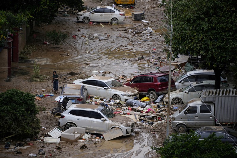 Seorang pria membersihkan rumah setelah hujan deras membanjiri kota Tangxia di Dongguan, provinsi Guangdong, Cina 9 September 2023. (REUTERS/Aly Song)
