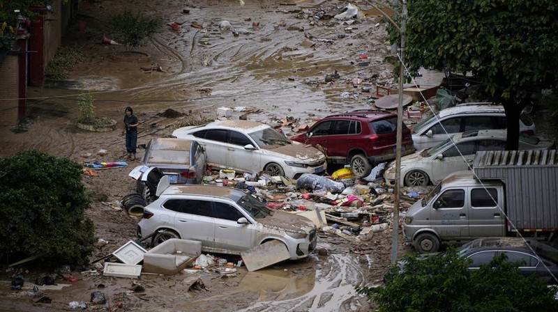 Seorang pria membersihkan rumah setelah hujan deras membanjiri kota Tangxia di Dongguan, provinsi Guangdong, Cina 9 September 2023. (REUTERS/Aly Song)