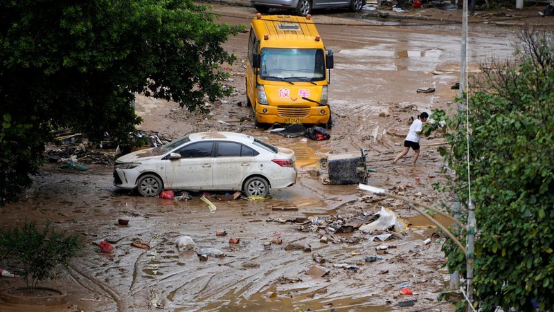 Seorang pria membersihkan rumah setelah hujan deras membanjiri kota Tangxia di Dongguan, provinsi Guangdong, Cina 9 September 2023. (REUTERS/Aly Song)