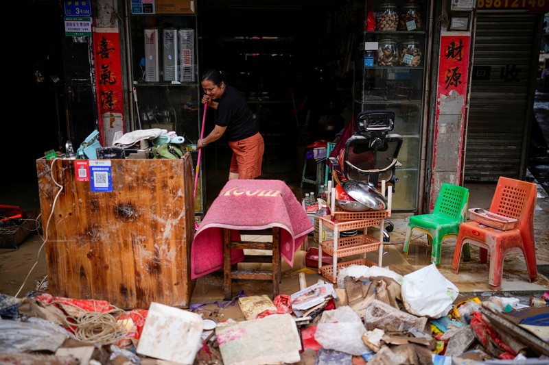 Seorang pria membersihkan rumah setelah hujan deras membanjiri kota Tangxia di Dongguan, provinsi Guangdong, Cina 9 September 2023. Seorang pria membersihkan rumah setelah hujan deras membanjiri kota Tangxia di Dongguan, provinsi Guangdong, Cina 9 September 2023. (REUTERS/Aly Song)