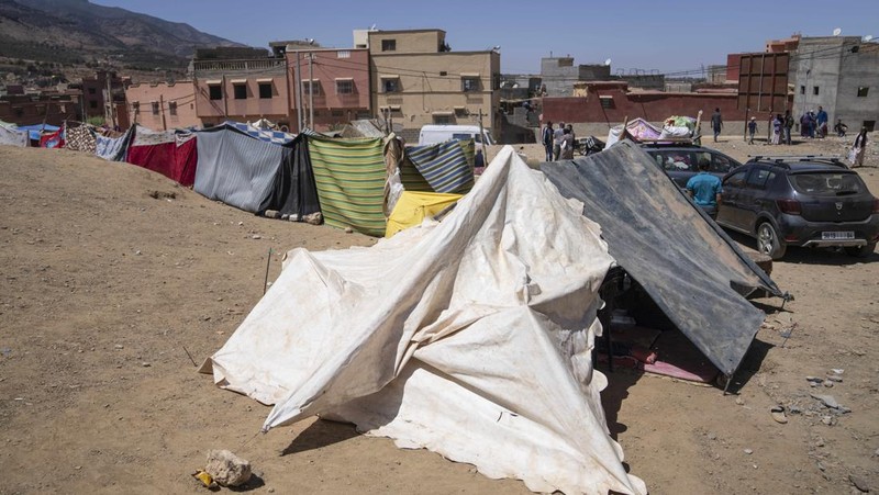 Orang-orang berlindung di tenda-tenda setelah rumah mereka rusak akibat gempa bumi, di kota Amizmiz, dekat Marrakesh, Maroko, Minggu, 10 September 2023. Kota-kota dan desa-desa di seluruh Pegunungan Atlas Maroko berduka atas kematian dan mencari bantuan setelah rekor gempa bumi mendatangkan kehancuran di seluruh wilayah minggu lalu. (AP Photo/Mosa'ab Elshamy)