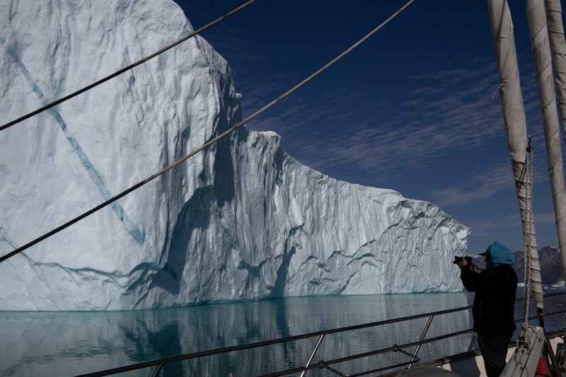 Ahli biologi Prancis di Greenlandia, Florian de Bettignies, mendokumentasikan gunung es yang terlepas dari gletser akibat suhu hangat di sepanjang Scoresby Sound Fjord, Greenland Timur pada 15 Agustus 2023. Ahli biologi Prancis di Greenlandia, Florian de Bettignies, mendokumentasikan gunung es yang terlepas dari gletser akibat suhu hangat di sepanjang Scoresby Sound Fjord, Greenland Timur pada 15 Agustus 2023. Pusat Penelitian Ilmiah Nasional Prancis sedang melakukan ekspedisi untuk menjelajahi fjord terpencil di Greenland, the sistem fjord terbesar di planet ini, yang masih belum banyak dipelajari. Ekspedisi tersebut, yang diselenggarakan oleh inisiatif Greenlandia yang dikelola sukarelawan Perancis, didedikasikan untuk memahami dampak perubahan iklim terhadap Scoresby Fjord dan penduduknya. (Photo by Olivier MORIN / AFP)