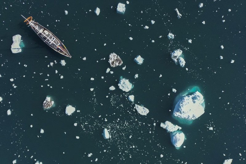 Ahli biologi Prancis di Greenlandia, Florian de Bettignies, mendokumentasikan gunung es yang terlepas dari gletser akibat suhu hangat di sepanjang Scoresby Sound Fjord, Greenland Timur pada 15 Agustus 2023. Pusat Penelitian Ilmiah Nasional Prancis sedang melakukan ekspedisi untuk menjelajahi fjord terpencil di Greenland, the sistem fjord terbesar di planet ini, yang masih belum banyak dipelajari. Ekspedisi tersebut, yang diselenggarakan oleh inisiatif Greenlandia yang dikelola sukarelawan Perancis, didedikasikan untuk memahami dampak perubahan iklim terhadap Scoresby Fjord dan penduduknya. (Photo by Olivier MORIN / AFP)