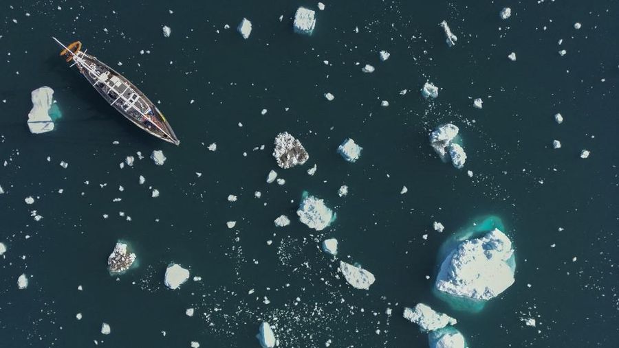 Ahli biologi Prancis di Greenlandia, Florian de Bettignies, mendokumentasikan gunung es yang terlepas dari gletser akibat suhu hangat di sepanjang Scoresby Sound Fjord, Greenland Timur pada 15 Agustus 2023. Pusat Penelitian Ilmiah Nasional Prancis sedang melakukan ekspedisi untuk menjelajahi fjord terpencil di Greenland, the sistem fjord terbesar di planet ini, yang masih belum banyak dipelajari. Ekspedisi tersebut, yang diselenggarakan oleh inisiatif Greenlandia yang dikelola sukarelawan Perancis, didedikasikan untuk memahami dampak perubahan iklim terhadap Scoresby Fjord dan penduduknya. (Photo by Olivier MORIN / AFP)