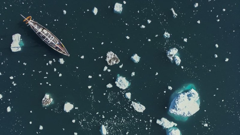 Ahli biologi Prancis di Greenlandia, Florian de Bettignies, mendokumentasikan gunung es yang terlepas dari gletser akibat suhu hangat di sepanjang Scoresby Sound Fjord, Greenland Timur pada 15 Agustus 2023. Pusat Penelitian Ilmiah Nasional Prancis sedang melakukan ekspedisi untuk menjelajahi fjord terpencil di Greenland, the sistem fjord terbesar di planet ini, yang masih belum banyak dipelajari. Ekspedisi tersebut, yang diselenggarakan oleh inisiatif Greenlandia yang dikelola sukarelawan Perancis, didedikasikan untuk memahami dampak perubahan iklim terhadap Scoresby Fjord dan penduduknya. (Photo by Olivier MORIN / AFP)