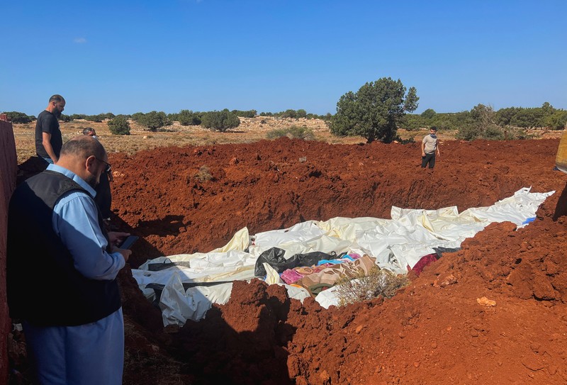 Orang-orang membawa jenazah korban untuk ditempatkan di kuburan massal setelah badai dahsyat dan hujan lebat di Libya, di Derna, Libya 12 September 2023. (REUTERS/Ayman Al-Sahili)