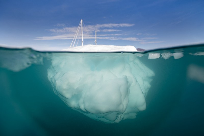 Ahli biologi Prancis di Greenlandia, Florian de Bettignies, mendokumentasikan gunung es yang terlepas dari gletser akibat suhu hangat di sepanjang Scoresby Sound Fjord, Greenland Timur pada 15 Agustus 2023. Pusat Penelitian Ilmiah Nasional Prancis sedang melakukan ekspedisi untuk menjelajahi fjord terpencil di Greenland, the sistem fjord terbesar di planet ini, yang masih belum banyak dipelajari. Ekspedisi tersebut, yang diselenggarakan oleh inisiatif Greenlandia yang dikelola sukarelawan Perancis, didedikasikan untuk memahami dampak perubahan iklim terhadap Scoresby Fjord dan penduduknya. (Photo by Olivier MORIN / AFP)