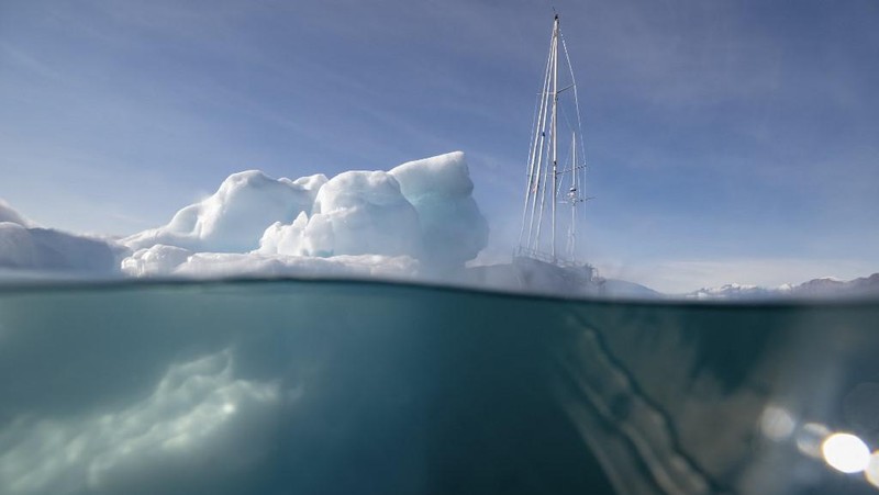 Ahli biologi Prancis di Greenlandia, Florian de Bettignies, mendokumentasikan gunung es yang terlepas dari gletser akibat suhu hangat di sepanjang Scoresby Sound Fjord, Greenland Timur pada 15 Agustus 2023. Pusat Penelitian Ilmiah Nasional Prancis sedang melakukan ekspedisi untuk menjelajahi fjord terpencil di Greenland, the sistem fjord terbesar di planet ini, yang masih belum banyak dipelajari. Ekspedisi tersebut, yang diselenggarakan oleh inisiatif Greenlandia yang dikelola sukarelawan Perancis, didedikasikan untuk memahami dampak perubahan iklim terhadap Scoresby Fjord dan penduduknya. (Photo by Olivier MORIN / AFP)