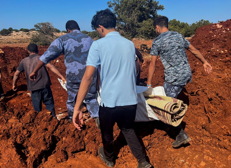 Orang-orang membawa jenazah korban untuk ditempatkan di kuburan massal setelah badai dahsyat dan hujan lebat di Libya, di Derna, Libya 12 September 2023. Orang-orang membawa jenazah korban untuk ditempatkan di kuburan massal setelah badai dahsyat dan hujan lebat di Libya, di Derna, Libya 12 September 2023. (REUTERS/Ayman Al-Sahili)