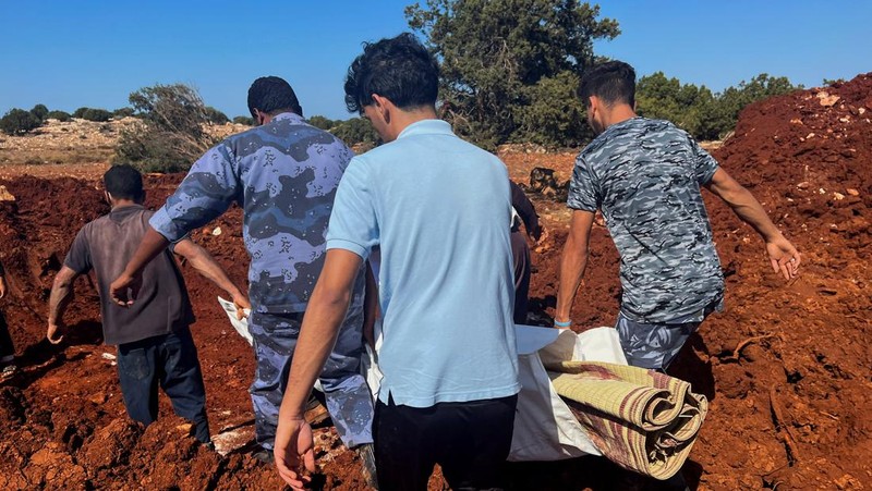 Orang-orang membawa jenazah korban untuk ditempatkan di kuburan massal setelah badai dahsyat dan hujan lebat di Libya, di Derna, Libya 12 September 2023. (REUTERS/Ayman Al-Sahili)