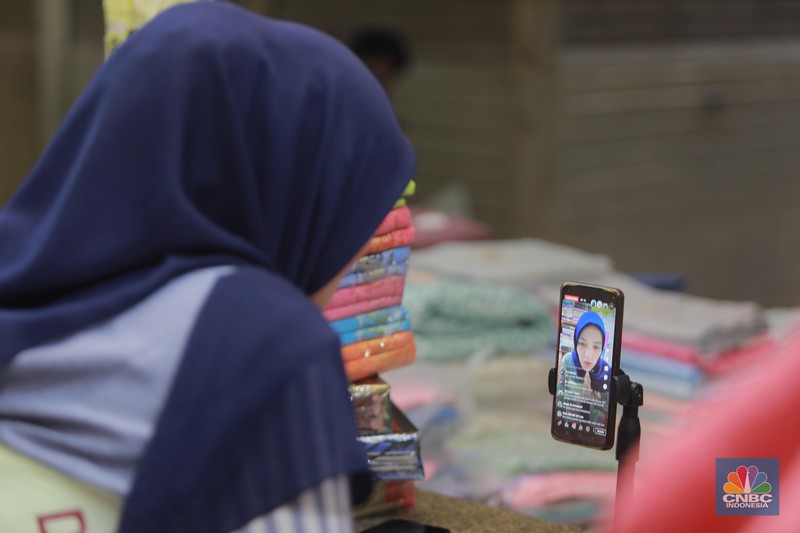Pedagang menawarkan produk daganganya secara daring melalui siaran langsung di Pasar Tanah Abang, Blok B, Jakarta, Rabu (13/9/2023). Pedagang menawarkan produk daganganya secara daring melalui siaran langsung di Pasar Tanah Abang, Blok B, Jakarta, Rabu (13/9/2023). (CNBC Indonesia/Muhammad Sabki)
