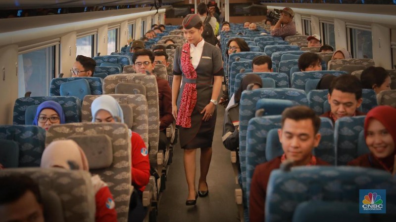Petugas Passenger Service Kereta Api Cepat Jakarta Bandung berpose di samping kereta cepat, di Stasiun Halim, Jakarta, Jumat, (15/9). (CNBC Indonesia/Muhammad Sabki)