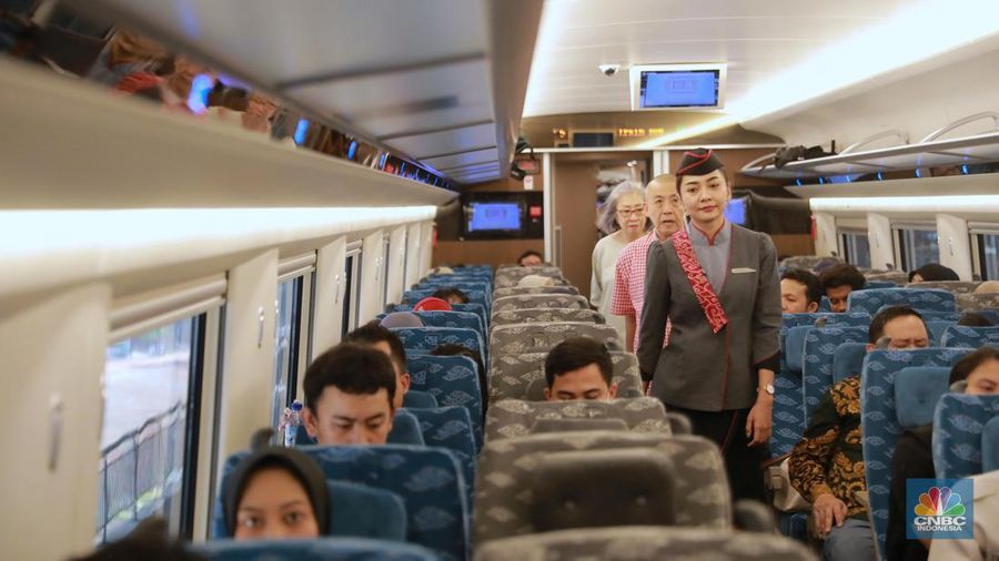 Petugas Passenger Service Kereta Api Cepat Jakarta Bandung berpose di samping kereta cepat, di Stasiun Halim, Jakarta, Jumat, (15/9). (CNBC Indonesia/Muhammad Sabki)