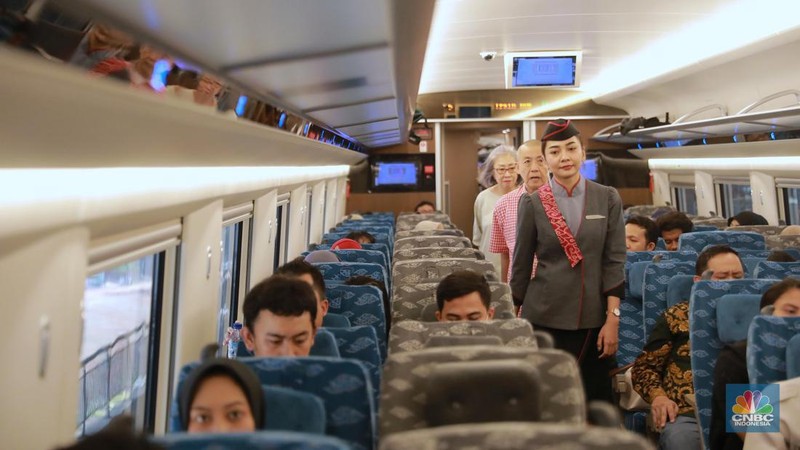 Petugas Passenger Service Kereta Api Cepat Jakarta Bandung berpose di samping kereta cepat, di Stasiun Halim, Jakarta, Jumat, (15/9). (CNBC Indonesia/Muhammad Sabki)