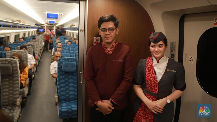Petugas Passenger Service Kereta Api Cepat Jakarta Bandung berpose di samping kereta cepat, di Stasiun Halim, Jakarta, Jumat, (15/9). (CNBC Indonesia/Muhammad Sabki)