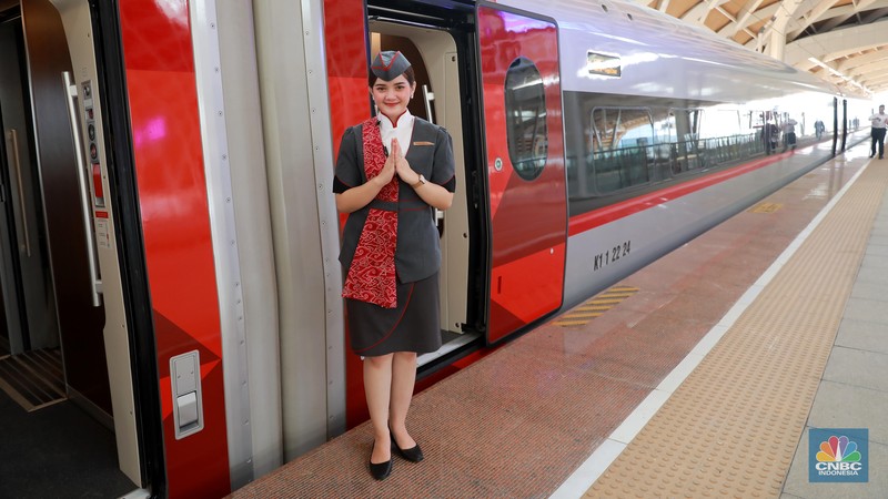 Petugas Passenger Service Kereta Api Cepat Jakarta Bandung berpose di samping kereta cepat, di Stasiun Halim, Jakarta, Jumat, (15/9). (CNBC Indonesia/Muhammad Sabki)