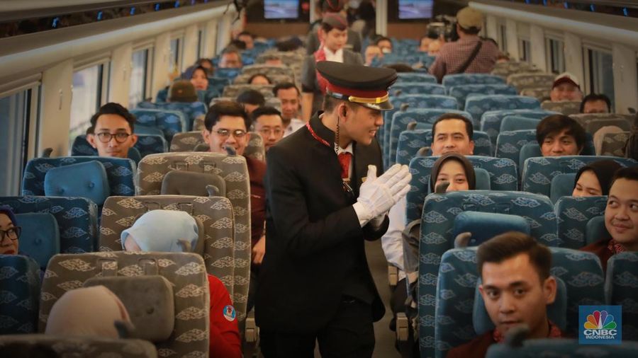 Sejumlah penumpang menunjukkan stiker penanda uji coba kereta cepat Jakarta Bandung di Halim - Tegalluar, Jumat, (15/9). (CNBC Indonesia/Muhammad Sabki)
