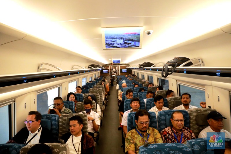 Sejumlah penumpang menunjukkan stiker penanda uji coba kereta cepat Jakarta Bandung di Halim - Tegalluar, Jumat, (15/9). (CNBC Indonesia/Muhammad Sabki)