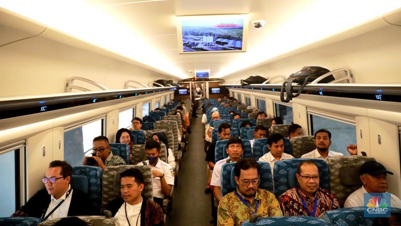 Sejumlah penumpang menunjukkan stiker penanda uji coba kereta cepat Jakarta Bandung di Halim - Tegalluar, Jumat, (15/9). (CNBC Indonesia/Muhammad Sabki)