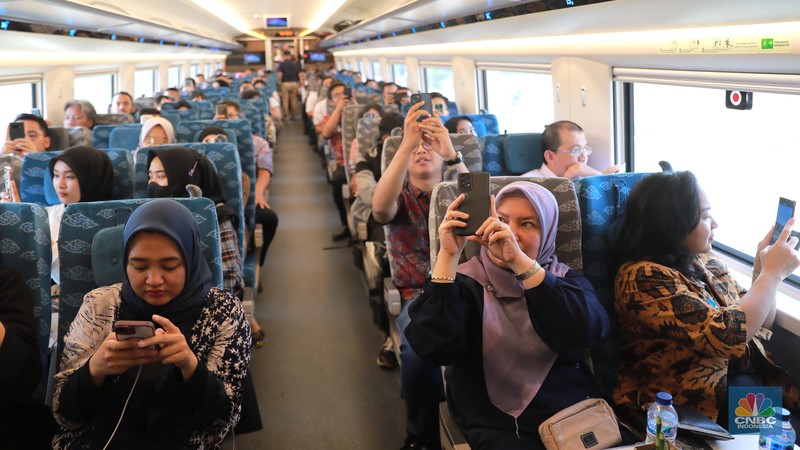 Sejumlah penumpang menunjukkan stiker penanda uji coba kereta cepat Jakarta Bandung di Halim - Tegalluar, Jumat, (15/9). (CNBC Indonesia/Muhammad Sabki)