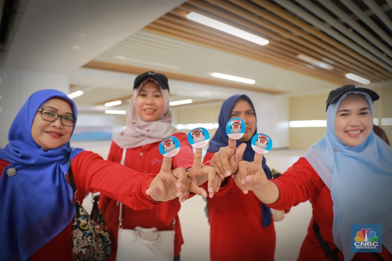 Sejumlah penumpang menunjukkan stiker penanda uji coba kereta cepat Jakarta Bandung di Halim - Tegalluar, Jumat, (15/9). (CNBC Indonesia/Muhammad Sabki)