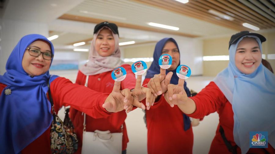 Sejumlah penumpang menunjukkan stiker penanda uji coba kereta cepat Jakarta Bandung di Halim - Tegalluar, Jumat, (15/9). (CNBC Indonesia/Muhammad Sabki)