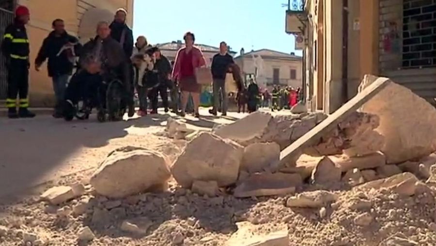 In this image made from video, emergency services lead people to safety, after an earthquake, in Norcia, Italy, Sunday, Oct. 30, 2016. A powerful earthquake with a preliminary magnitude of 6.6 has rocked the same area of central and southern Italy hit by quake in August and a pair of aftershocks last week, sending already quake-damaged buildings crumbling after a week of temblors that have left thousands homeless. (Sky Italia via AP)