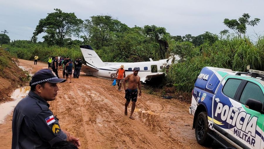 Orang-orang melihat pesawat setelah jatuh yang menyebabkan 14 orang tewas di Barcelos, Negara Bagian Amazonas Brasil 16 September 2023. (REUTERS/Wellington Melo)