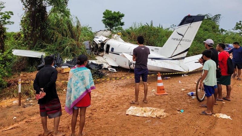 Orang-orang melihat pesawat setelah jatuh yang menyebabkan 14 orang tewas di Barcelos, Negara Bagian Amazonas Brasil 16 September 2023. (REUTERS/Wellington Melo)