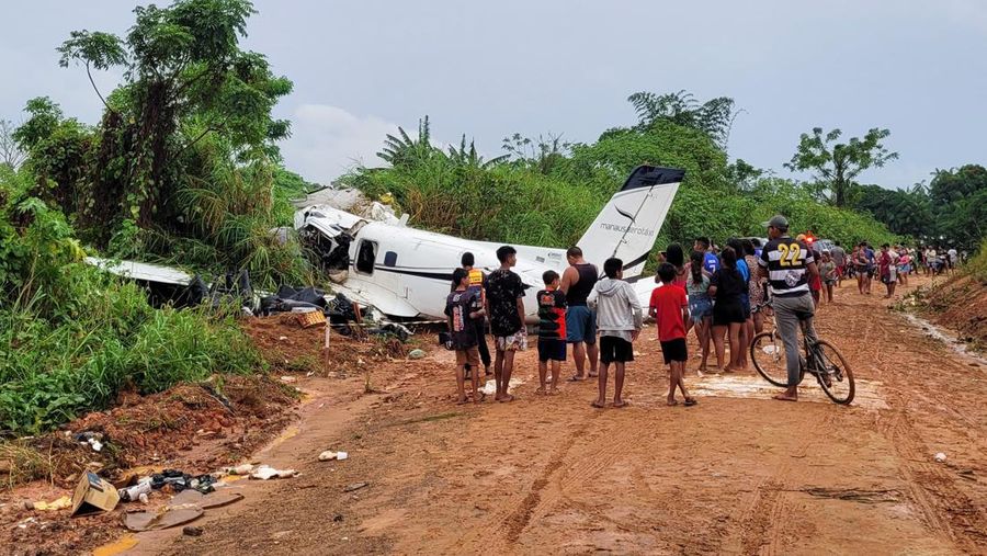 Orang-orang melihat pesawat setelah jatuh yang menyebabkan 14 orang tewas di Barcelos, Negara Bagian Amazonas Brasil 16 September 2023. (REUTERS/Wellington Melo)