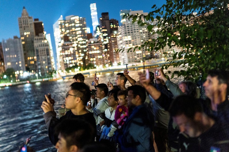 Seorang wanita melihat drone yang membuat tampilan 3-D di luar Markas Besar PBB yang meminta perhatian terhadap hutan hujan Amazon dan perubahan iklim di New York AS, 15 September 2023. (REUTERS/Eduardo Munoz)