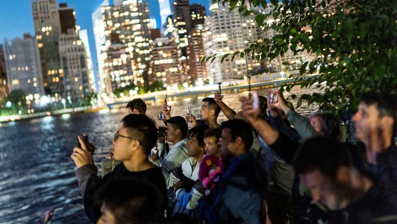 Seorang wanita melihat drone yang membuat tampilan 3-D di luar Markas Besar PBB yang meminta perhatian terhadap hutan hujan Amazon dan perubahan iklim di New York AS, 15 September 2023. (REUTERS/Eduardo Munoz)