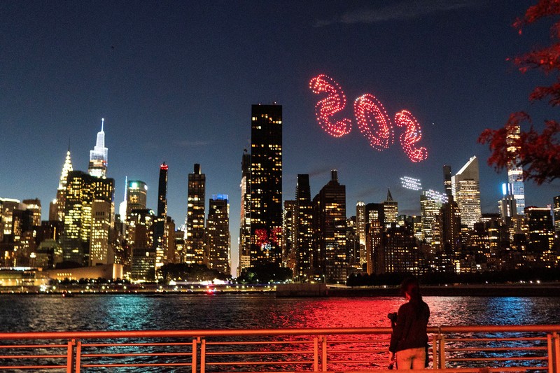 Seorang wanita melihat drone yang membuat tampilan 3-D di luar Markas Besar PBB yang meminta perhatian terhadap hutan hujan Amazon dan perubahan iklim di New York AS, 15 September 2023. (REUTERS/Eduardo Munoz)
