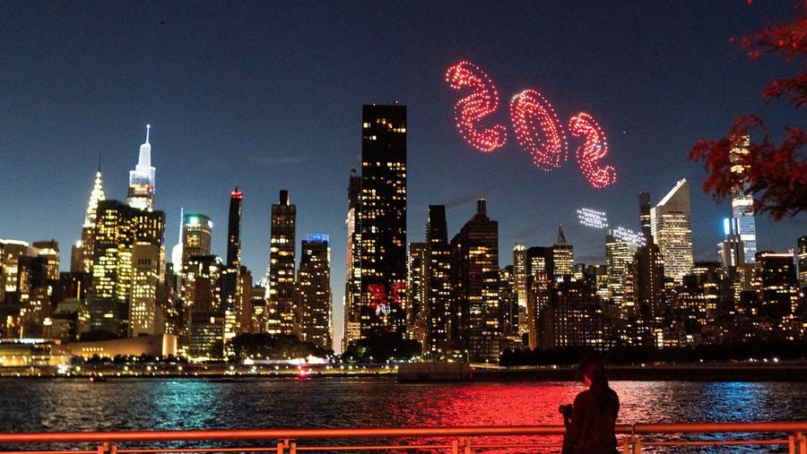 Seorang wanita melihat drone yang membuat tampilan 3-D di luar Markas Besar PBB yang meminta perhatian terhadap hutan hujan Amazon dan perubahan iklim di New York AS, 15 September 2023. (REUTERS/Eduardo Munoz)