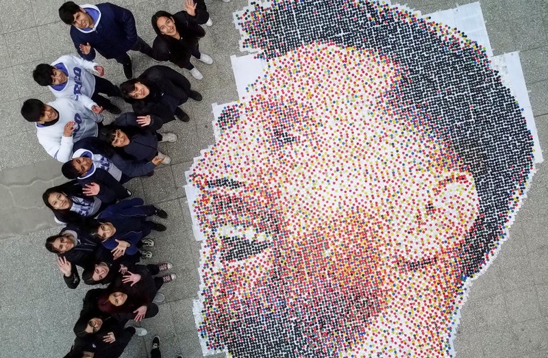 High school students stand next to the mural they made with plastic bottle caps depicting Argentina's soccer superstar Lionel Messi, nine months after Argentina won the soccer World Cup Qatar 2022, in Grand Bourg, on the outskirts of Buenos Aires, Argentina September 19, 2023. REUTERS/Agustin Marcarian
