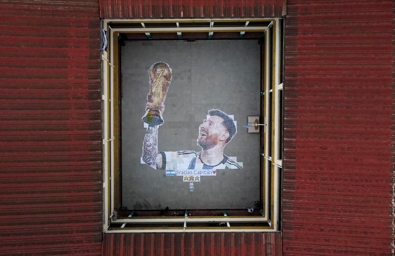 High school students stand next to the mural they made with plastic bottle caps depicting Argentina's soccer superstar Lionel Messi, nine months after Argentina won the soccer World Cup Qatar 2022, in Grand Bourg, on the outskirts of Buenos Aires, Argentina September 19, 2023. REUTERS/Agustin Marcarian