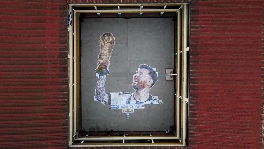 High school students stand next to the mural they made with plastic bottle caps depicting Argentina's soccer superstar Lionel Messi, nine months after Argentina won the soccer World Cup Qatar 2022, in Grand Bourg, on the outskirts of Buenos Aires, Argentina September 19, 2023. REUTERS/Agustin Marcarian