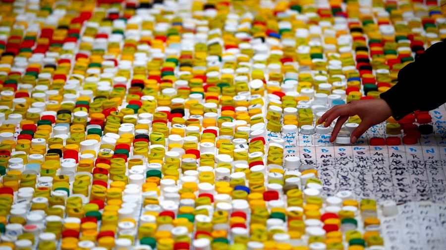 High school students stand next to the mural they made with plastic bottle caps depicting Argentina's soccer superstar Lionel Messi, nine months after Argentina won the soccer World Cup Qatar 2022, in Grand Bourg, on the outskirts of Buenos Aires, Argentina September 19, 2023. REUTERS/Agustin Marcarian