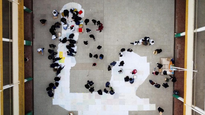 High school students stand next to the mural they made with plastic bottle caps depicting Argentina's soccer superstar Lionel Messi, nine months after Argentina won the soccer World Cup Qatar 2022, in Grand Bourg, on the outskirts of Buenos Aires, Argentina September 19, 2023. REUTERS/Agustin Marcarian
