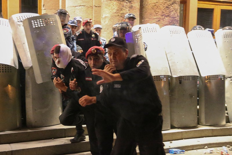 ARMENIA-AZERBAIJAN/PROTESTS Protesters sit in front of law enforcement officers near the government building during a rally to support ethnic Armenians in Nagorno-Karabakh following Azerbaijani armed forces' offensive operation executed in the region, in Yerevan, Armenia, September 20, 2023. REUTERS/Irakli Gedenidze